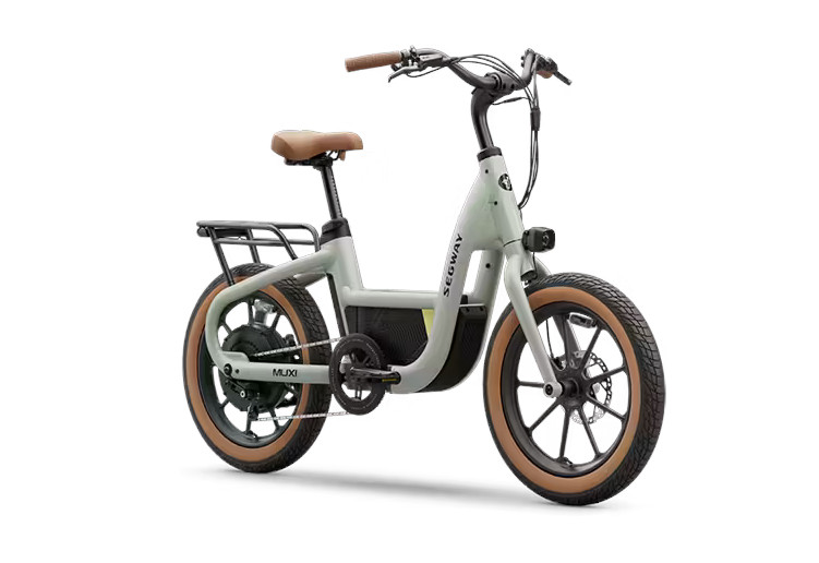 Product photo of the Segway MuXi ebike from the right quarter view. From this angle you can see the left side of the bike, from the tan wall front tire, the light on the fork, the curving handlebar, the main tube extending down from the head tube to then cradle the battery before continuing back towards the rear wheel, along the the tan wall rear tire, rear rack, and brown seat