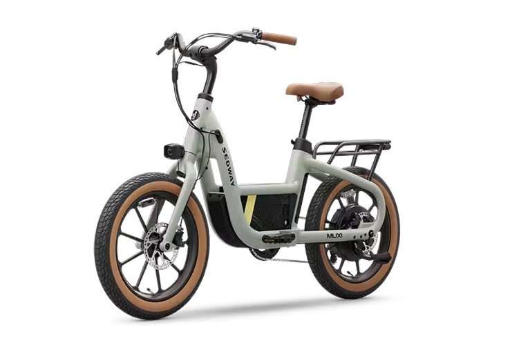 Product photo of the Segway MuXi ebike from the left quarter view. From this angle you can see the left side of the bike, from the tan wall front tire, the light on the fork, the curving handlebar, the main tube extending down from the head tube to then cradle the battery before continuing back towards the rear wheel, along the the tan wall rear tire, rear rack, and brown seat